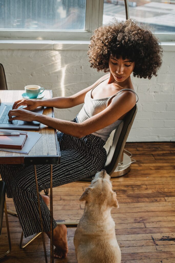 Top roles for remote staffing - Remote worker at home with her dog.